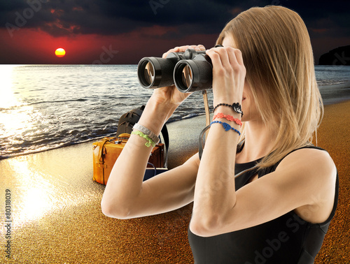 woman with binocular on the beach