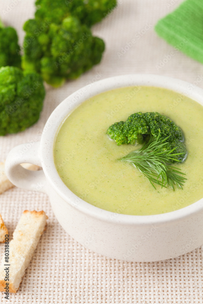 Healthy green broccoli soup with croutons in a white dish Healthy green broccoli soup with croutons in a white dish