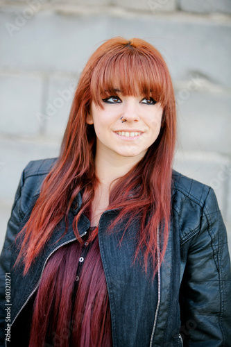 Rebellious teenager girl with red hair smiling photo