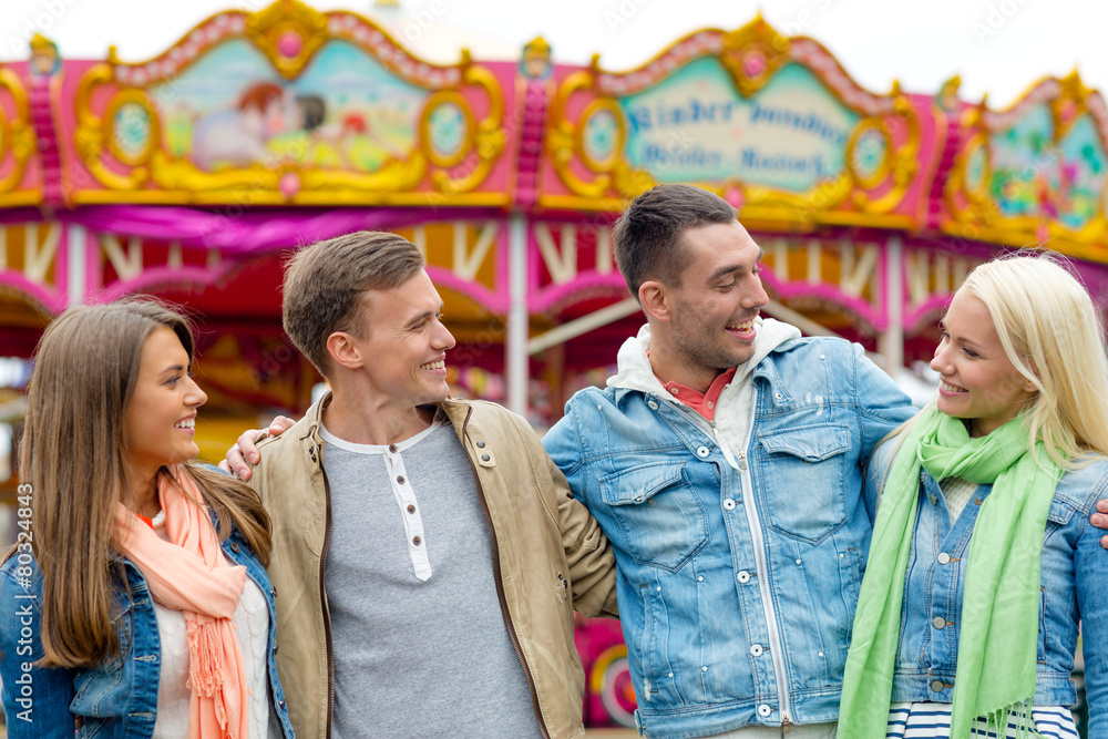 Fototapeta premium group of smiling friends in amusement park