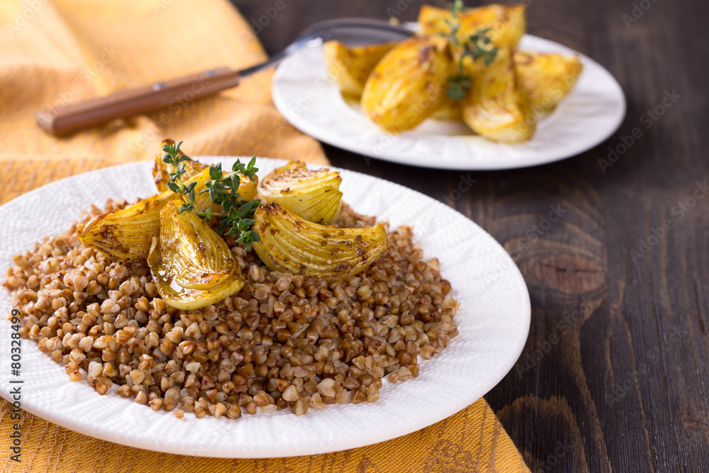 Buckwheat porridge with baked onions on a wooden table Buckwheat porridge with baked onions on a wooden table