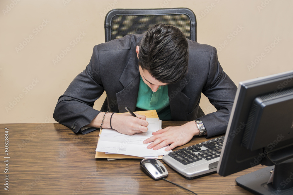 Stylish businessman sitting at his desk working Stylish businessman sitting at his desk working