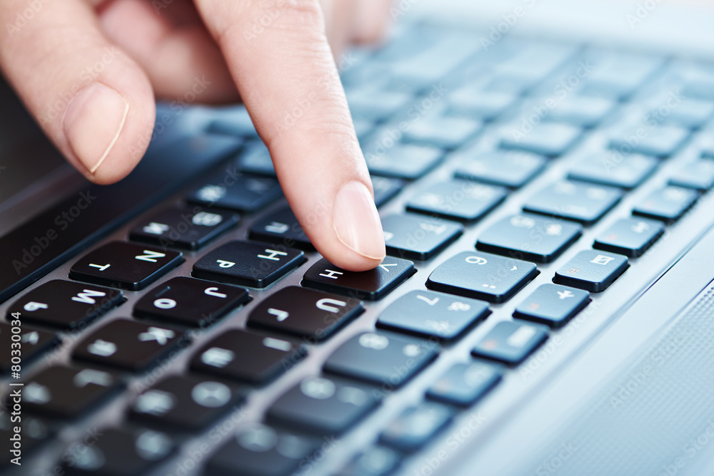 Female hand on laptop keyboard closeup