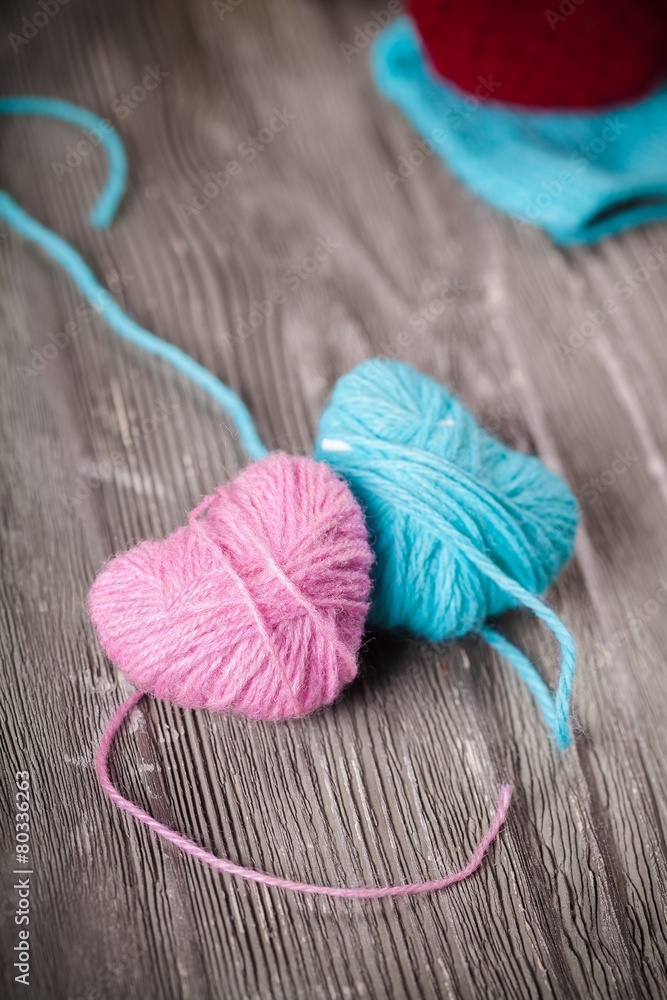 Crocheting. Crochet pink hearts  and yarn on wooden background