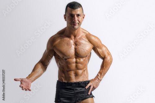 Strong bodybuilder with six pac, shoulders,biceps, triceps,chest