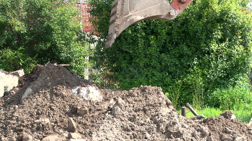 Excavator digging on the construction site; slight backzoom