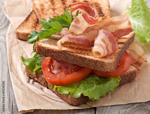 hot big sandwich, toast and bacon with tomato, parsley, lettuce