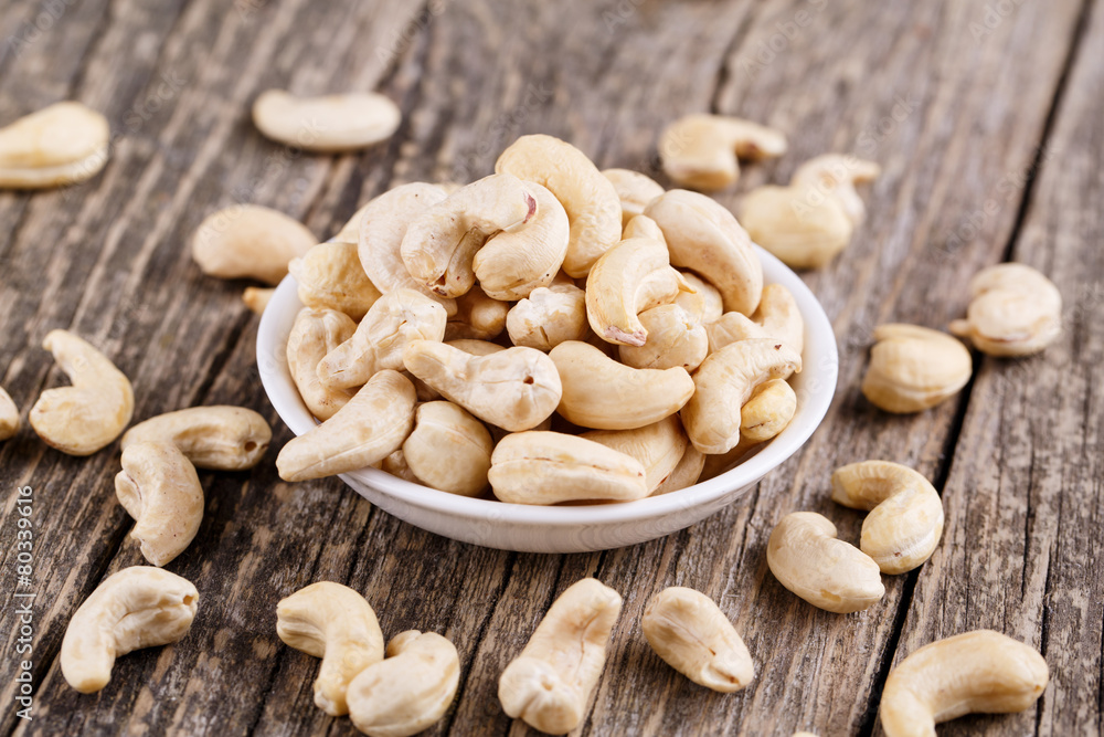 Cashew nuts on a plate on wooden background. Cashew nuts on a plate on wooden background.