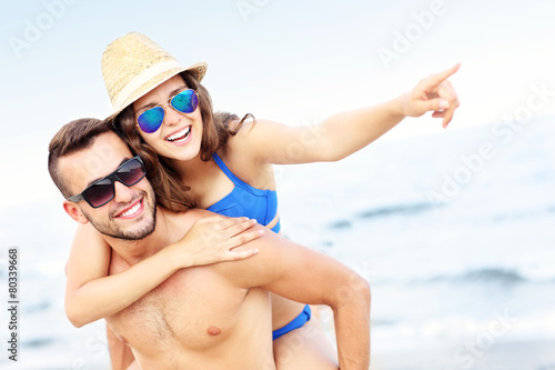 Young couple pointing at something at the beach