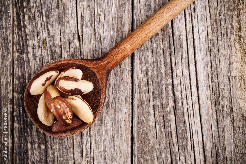 Brazil nuts on a spoon on wooden background. Brazil nuts on a spoon on wooden background.