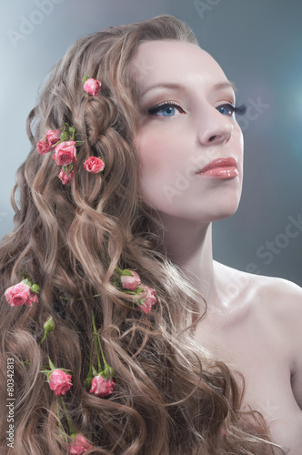 Beauty portrait with red roses in hair