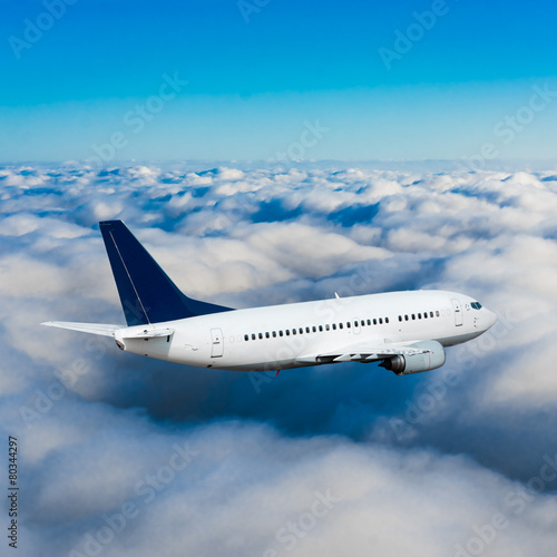 Passenger airplane flying above dramatic clouds