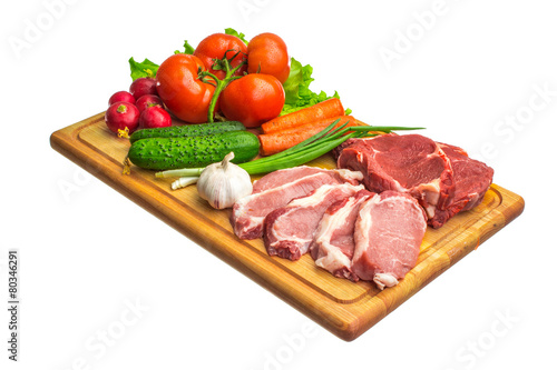 Fresh raw meat and vegetables on a cutting board