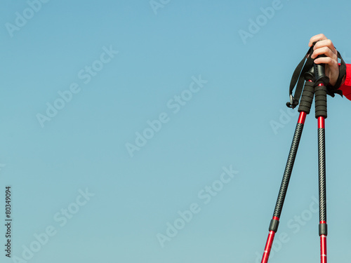 Foto Nordic walking. Red sticks on blue sky background