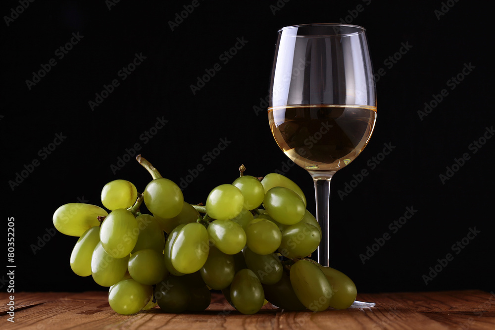 Wineglass and grape on wooden table