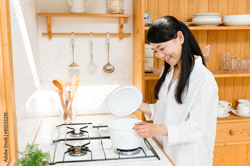 young asian woman cooking image