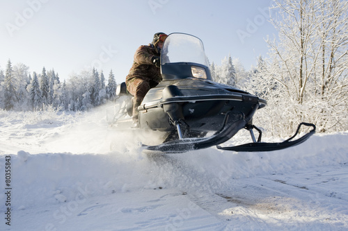 snowmobile driving through a harsh winter landscape