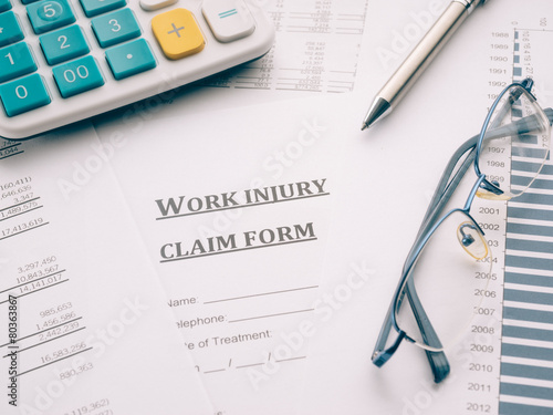 work injury claim form on desk.