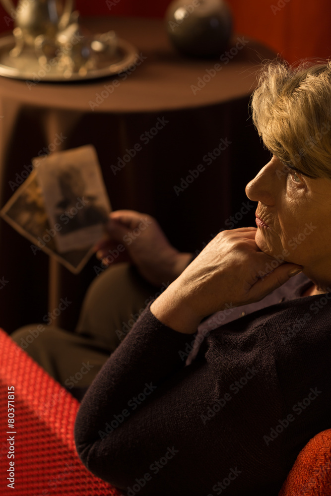 Sad pensioner holding old pictures Sad pensioner holding old pictures