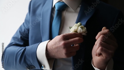 The groom wears a tie and cufflinks boutonniere