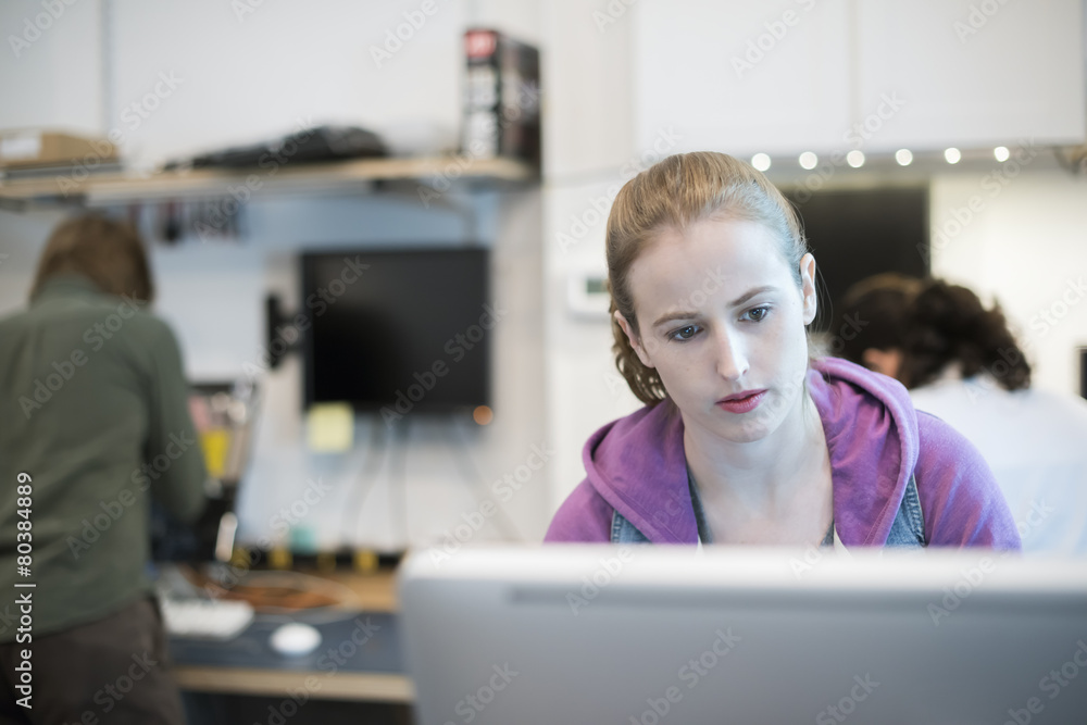 Computer Repair Shop,. A woman at a computer frowning at the screen. Computer Repair Shop,. A woman at a computer frowning at the screen.