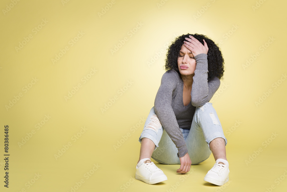 Unhappy girl being sad on yellow background. Unhappy girl being sad on yellow background.