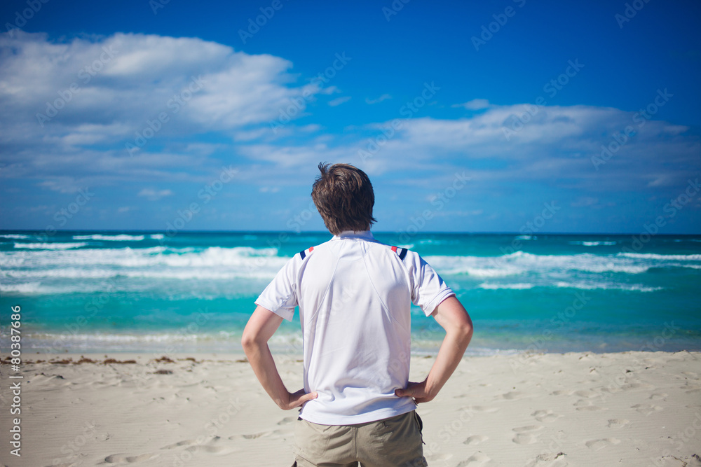 Handsome young man against bright beach background, looking at Handsome young man against bright beach background, looking at