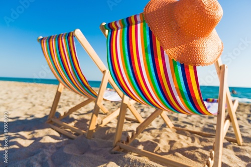 Foto Deck. two deckchairs on a pebbled beach, facing out to sea