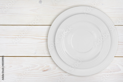 Pile of two white plates on bleached wooden plank background