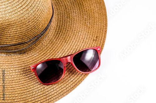 Red sunglasses and beach hat isolated on white background