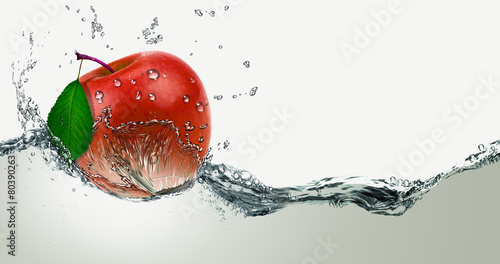 Red,juicy Apple in a spray of water.
