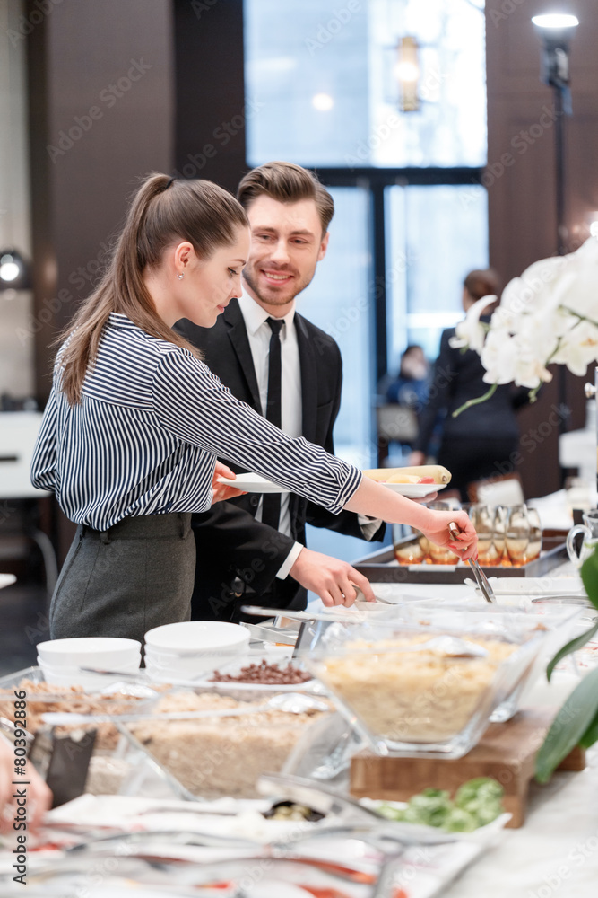Business professionals by the buffet table - obrazy, fototapety, plakaty 