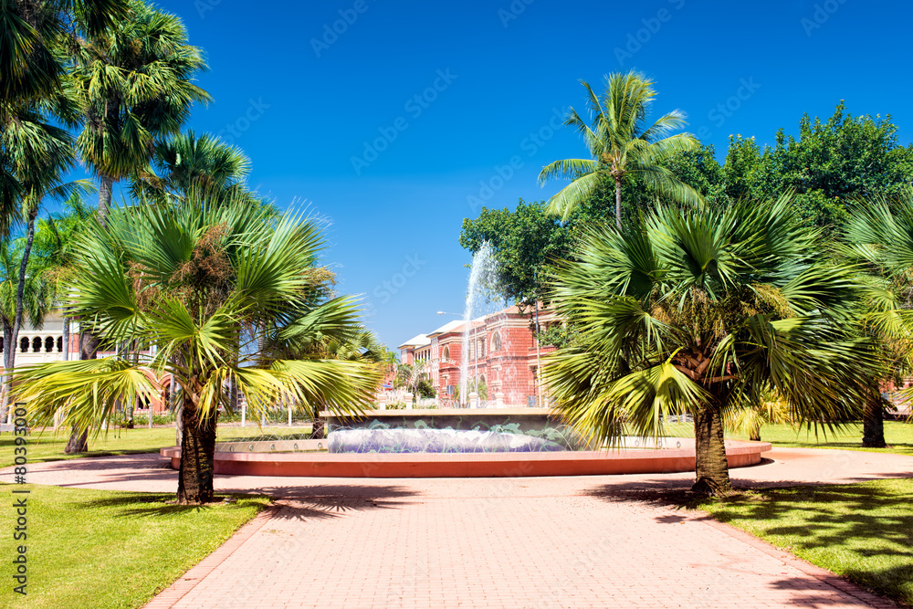 A fountain in the park surrounded by palm trees