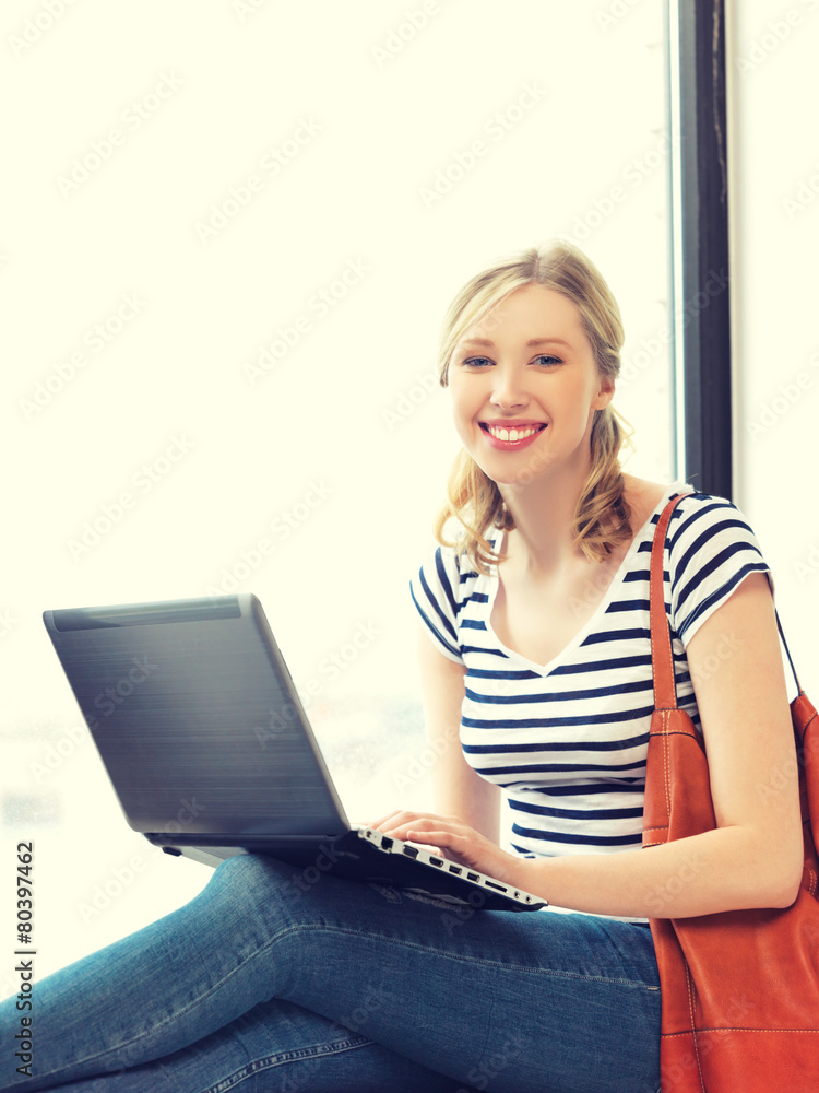 Naklejka premium happy teenage girl with laptop computer