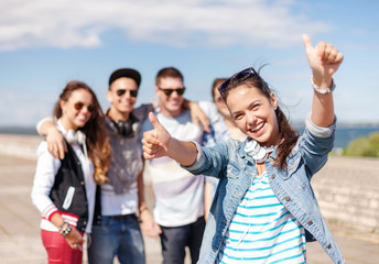 teenage girl with headphones and friends outside