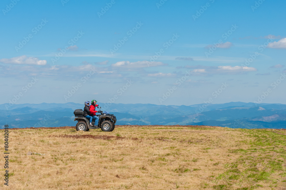 Quad biking in the mountains. Equipped ATV driver and passenger Quad biking in the mountains. Equipped ATV driver and passenger