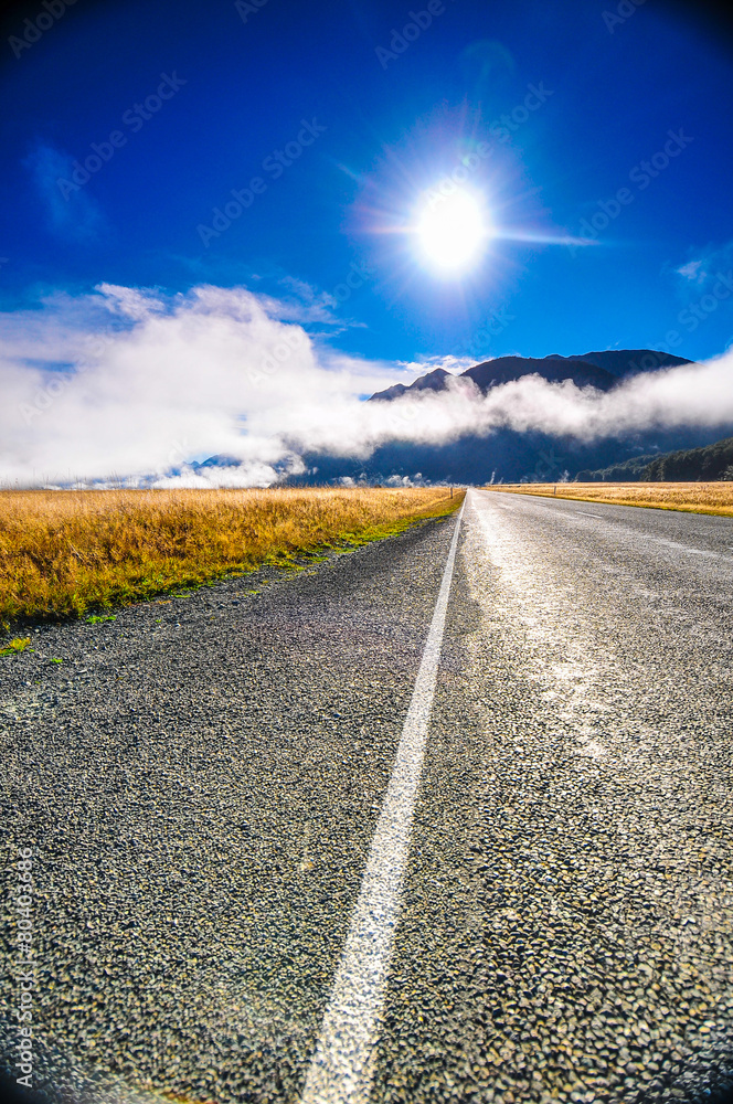 Fototapeta premium Straight way to the mountain Asphalt road over cloudscape