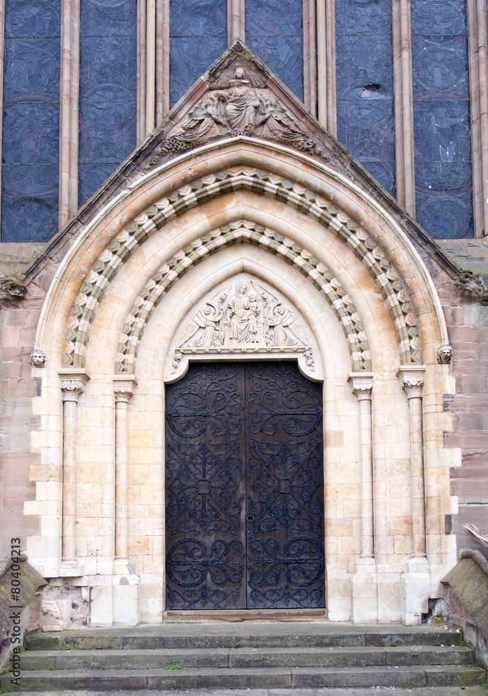 Large ornate wood door leads into a Cathedral