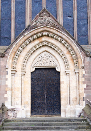 Large ornate wood door leads into a Cathedral