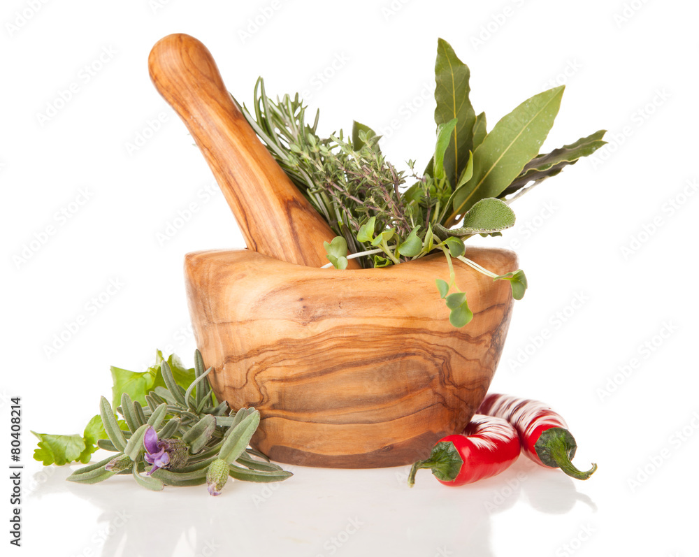Wooden mortar with herbs on white background