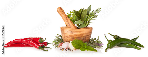 Wooden mortar with herbs on white background