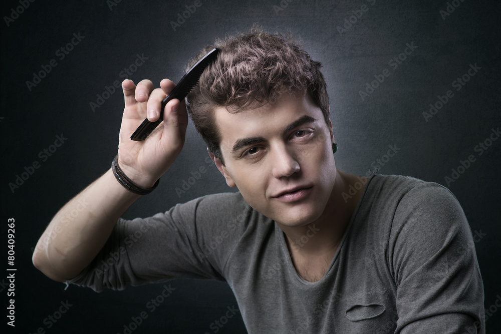 Young man combing his hair