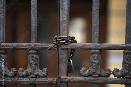 Iron gate scured with a chain and a padlock photo