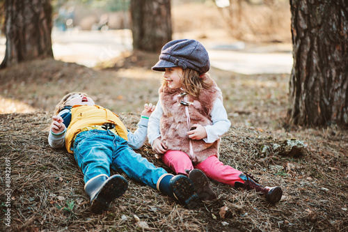happy toddler friends playing in sunny forest