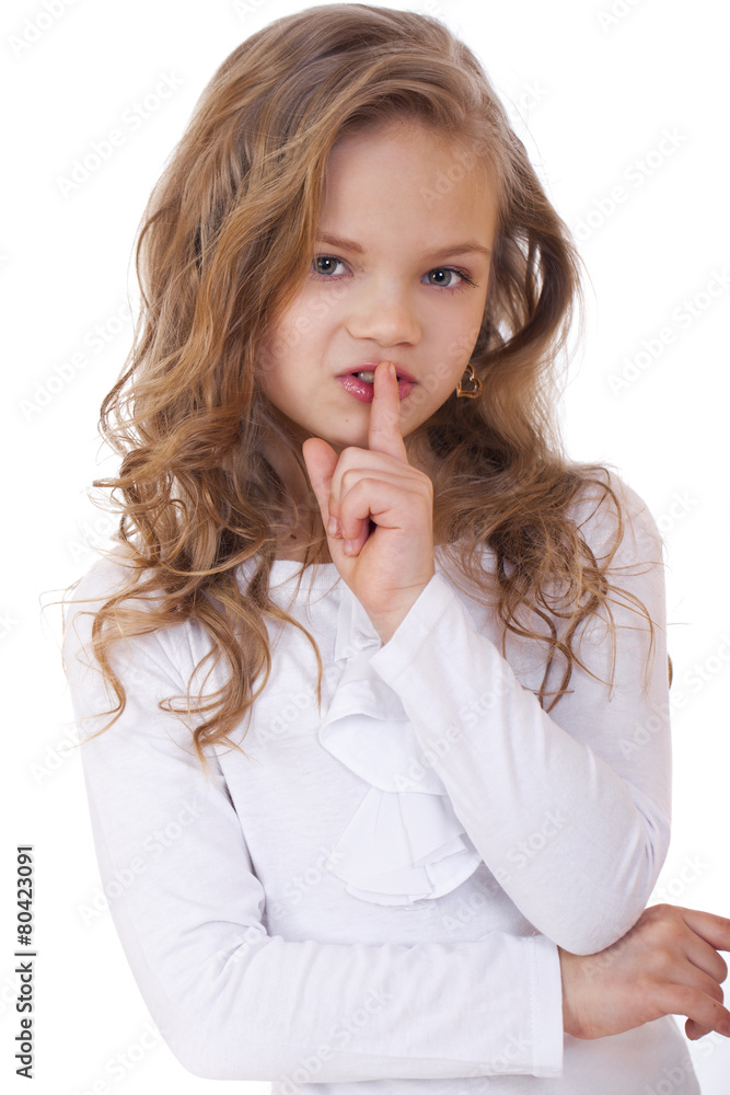 Little girl has put forefinger to lips as sign of silence Little girl has put forefinger to lips as sign of silence