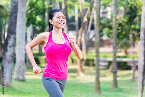 Asian woman running in park for fitness © Kzenon