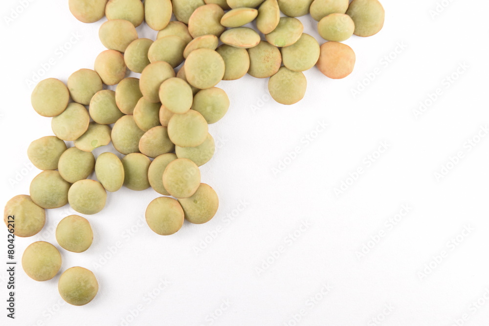Green lentils on a white background. Green lentils on a white background.
