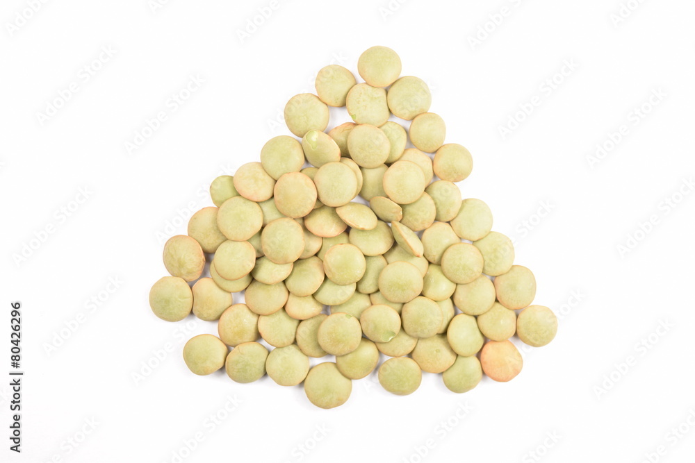 Green lentils on a white background. Green lentils on a white background.