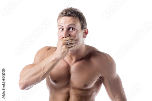 Young man covering mouth with hand, not laughing