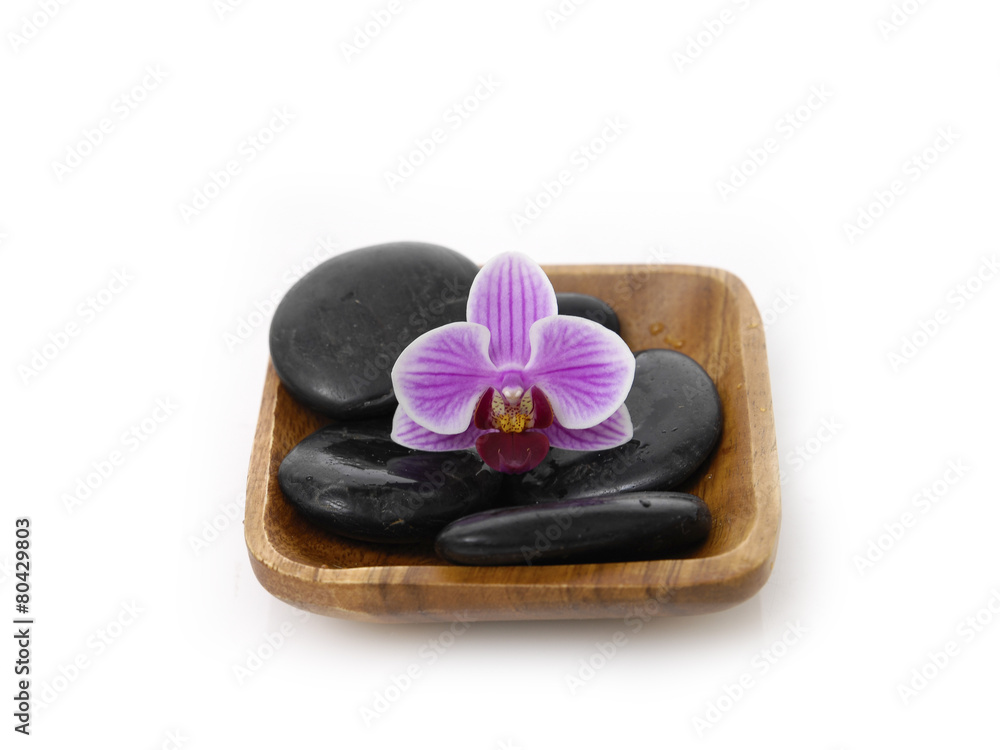 Fototapeta premium pink orchid with black stones on wooden bowl